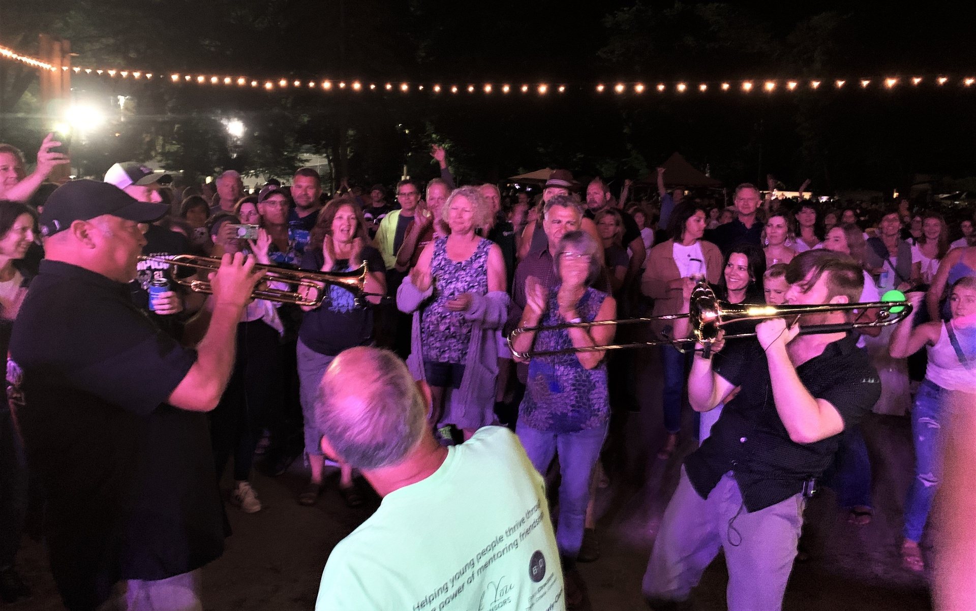 Horns playing into a packed crowd